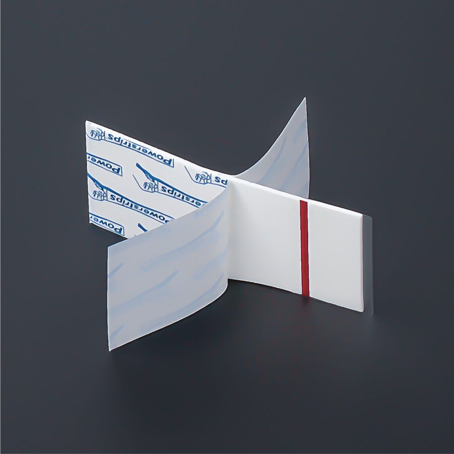 Tesa Powerstripes® Large 5x2cm Doppelseitige Klebestreifen beidseitig abgezogen auf dunklem Untergrund