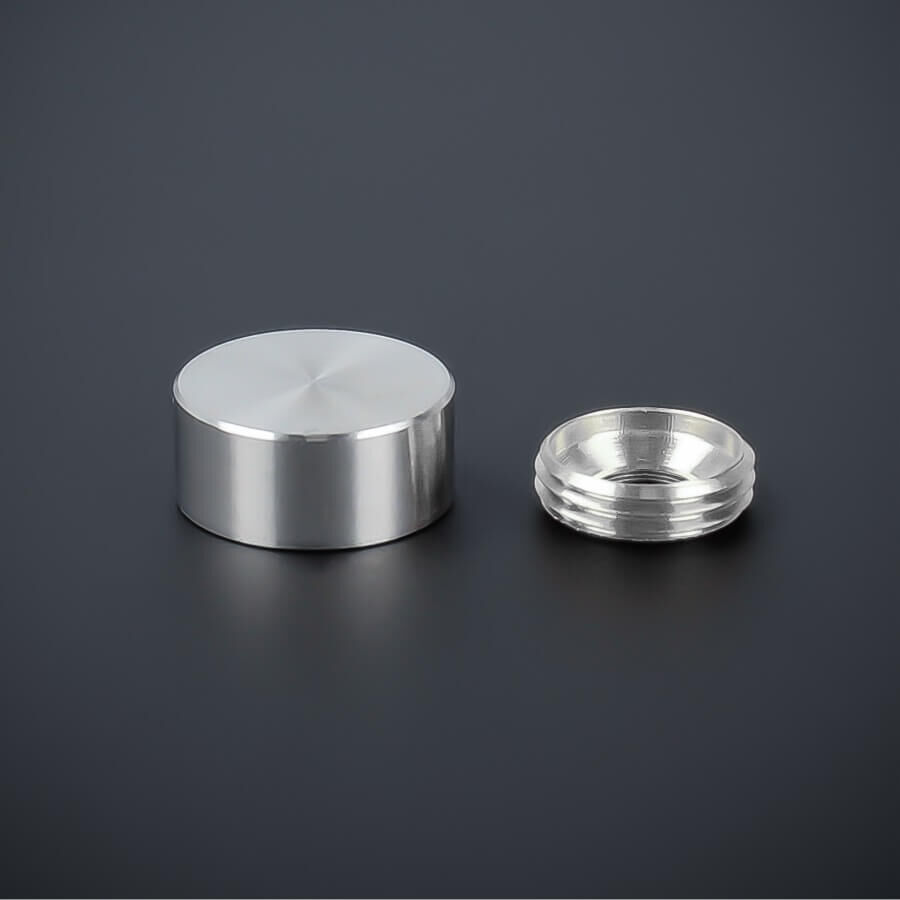 Zierkappe Edelstahl 15mm flach liegend mit Gewindering auf dunklem Untergrund