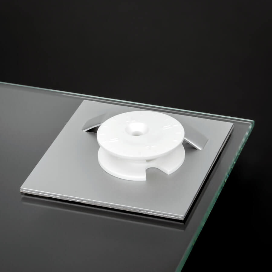 Glasplattenmontage selbstklebend 70x70mm mit Exzenterscheibe auf Glasplatte klebend mit schwarzen Hintergrund
