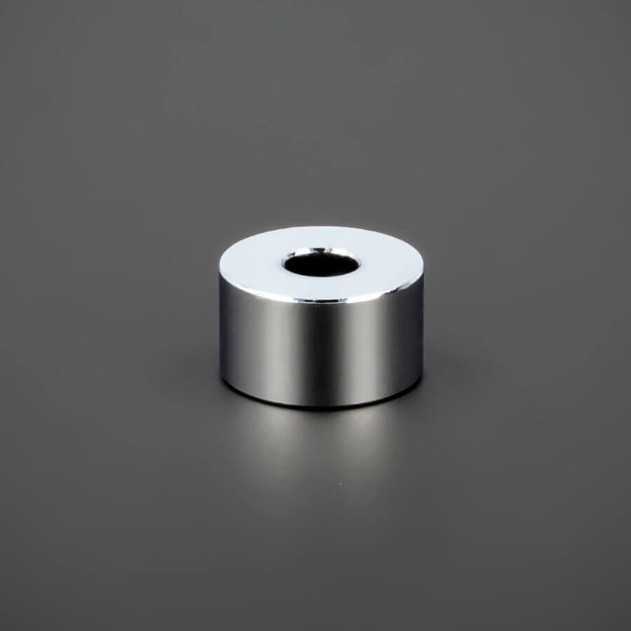 Distanzstück M6 Messing verchromt glänzend Ø 18 mm liegend auf dunklem Untergrund