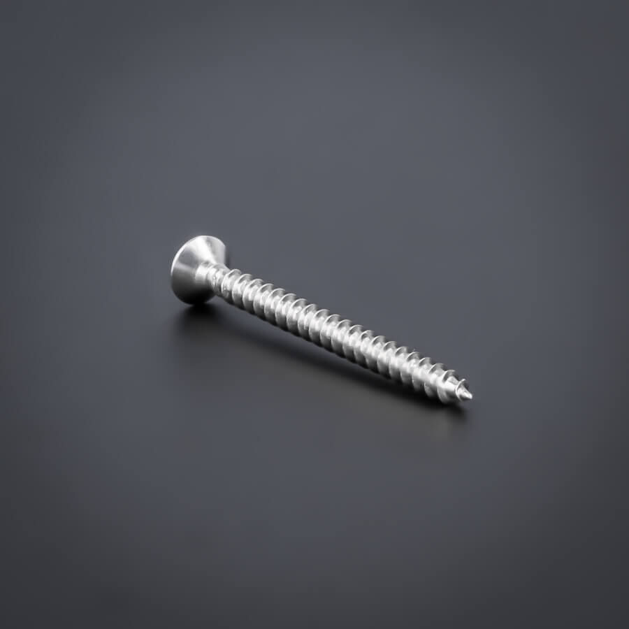 Schraube 3x30 mm Edelstahl V2A - A2 Senkkopf verstärkter Kopf | Kreuz gedreht liegend auf dunklem Untergrund