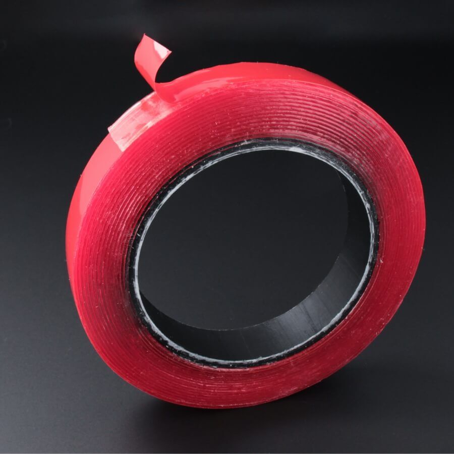 Doppelseitiges Montageklebeband transparent stark haftend 19 mm Rolle auf dunklem Hintergrund