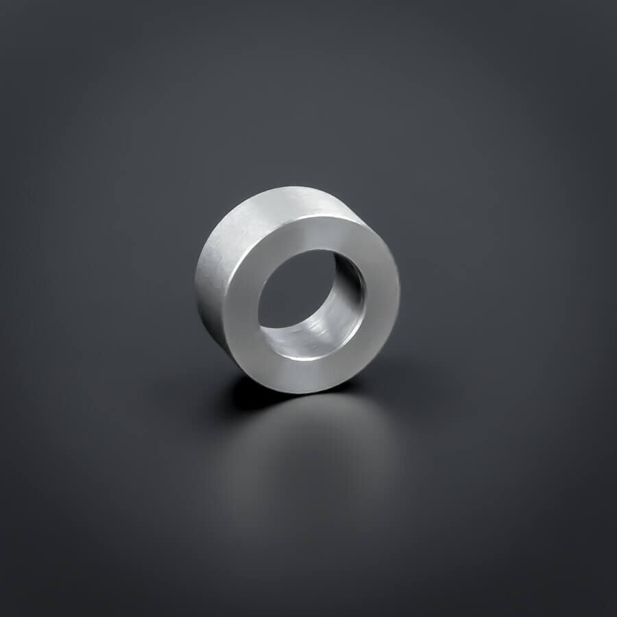 Distanz-Ring M10 Edelstahl Ø 18 mm WA: 8 mm stehend von vorne auf dunklem Untergrund