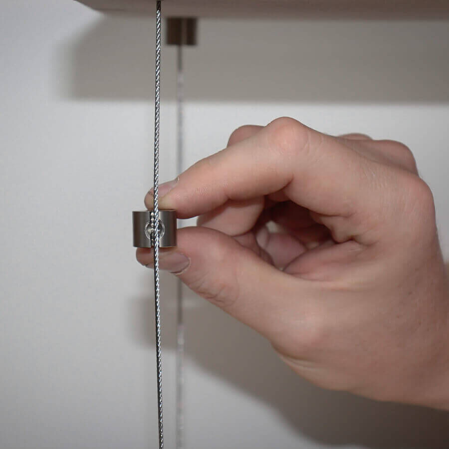 Seilklemme Draht Seilstopper Klemmstopper Edelstahl V2A befestigt an einem Drahtseil mit hellem Hintergrund
