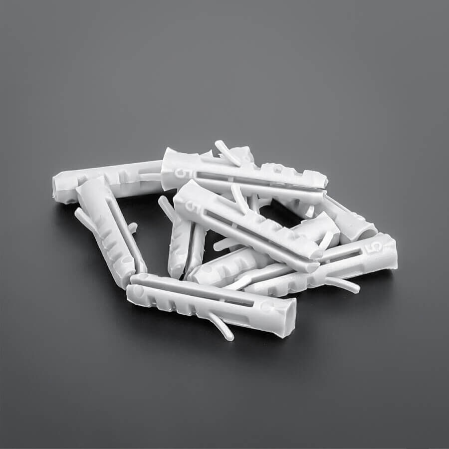 Dübel S5 Nylon Ø 5x25 mm Haufen mit mehreren Dübeln auf dunklem Untergrund