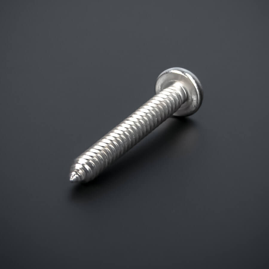 Schraube 6,3x60 mm Edelstahl V2A - A2 Linsenkopf Blechschraube Kreuz gedreht liegend auf dunklem Untergrund