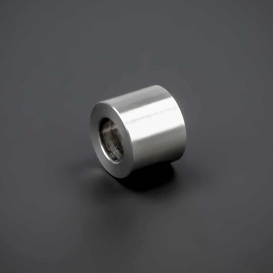 Distanz-Ring Edelstahl Ø 15 x 12 mm M8 liegend auf dunklem Untergrund