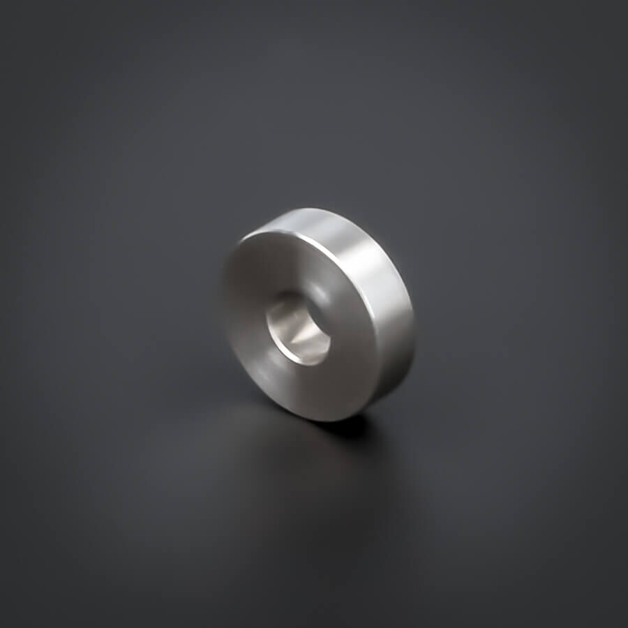 Distanzring M6 Abstandsrohr V2A Ø18x5mm stehend gedreht auf dunklem Untergrund